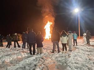 Christmas Tree bonfire with community members watching